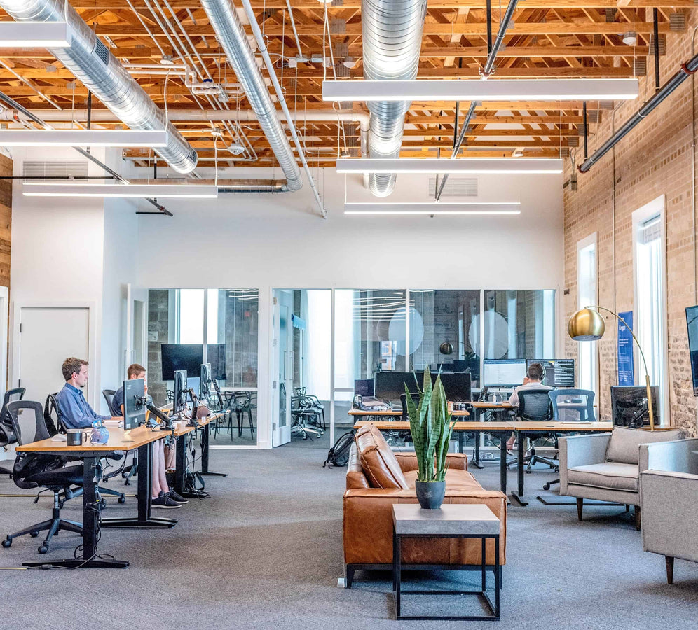 modern office with open floor plan and employees sitting at desks working on computers