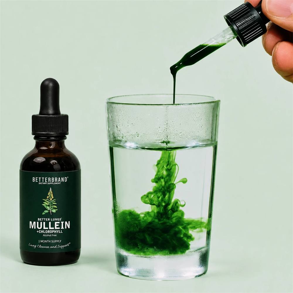 A dropper of BetterLungs® Mullein + Chlorophyll dispersing through a glass of water beside the bottle